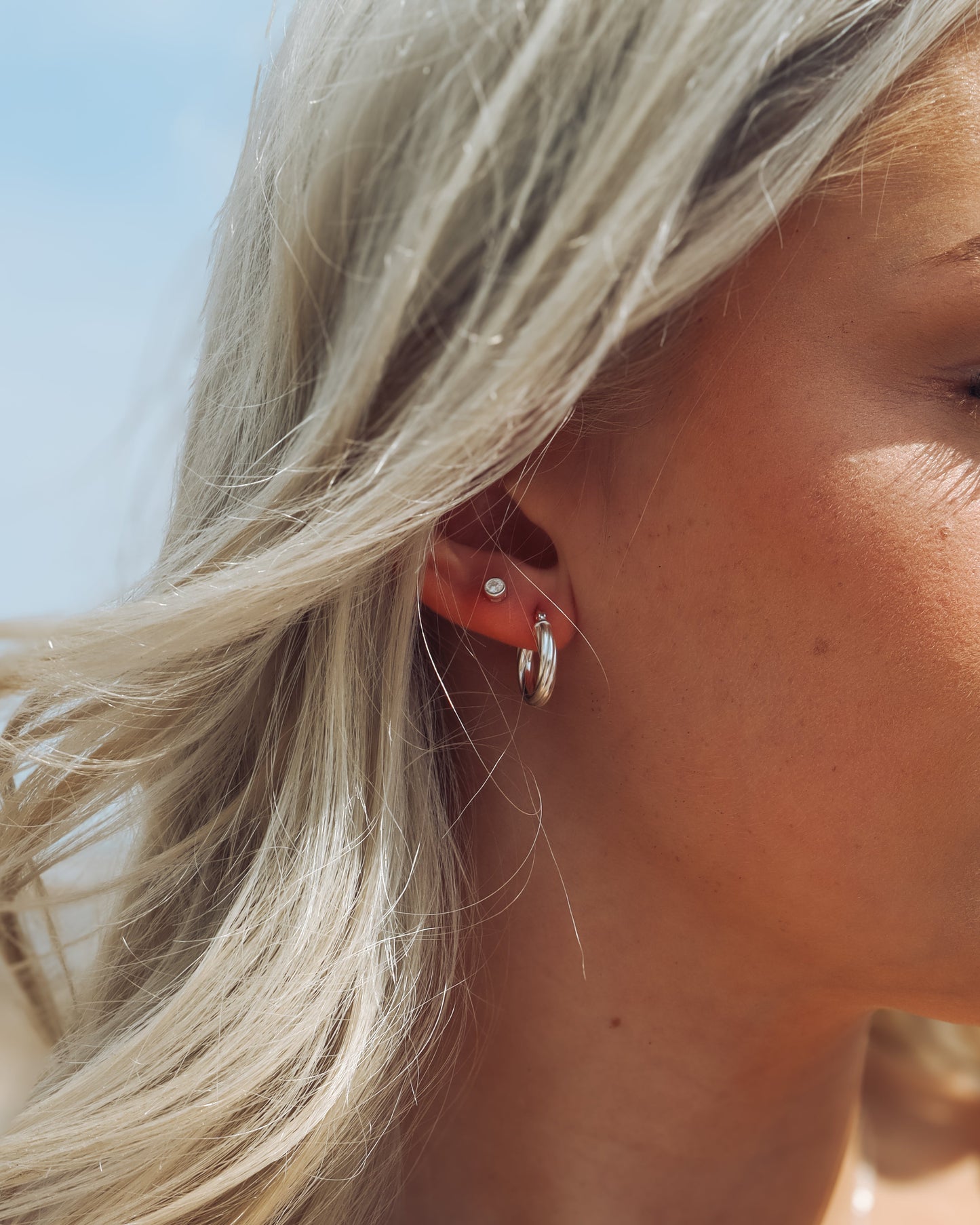 Close-up of a person wearing earrings with a blurred background