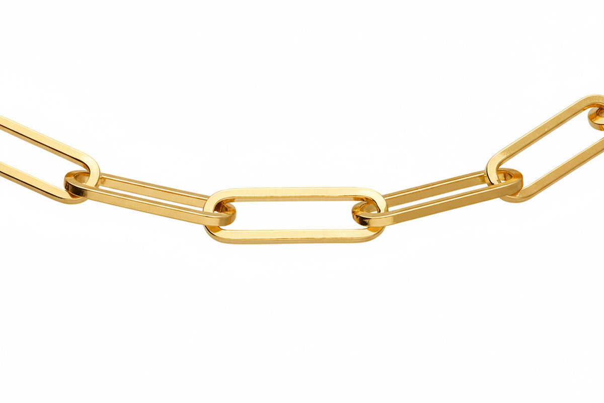 A close-up of a gold paperclip chain link necklace on a solid white background.