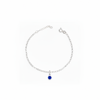 Silver bracelet with a blue gemstone on a white background