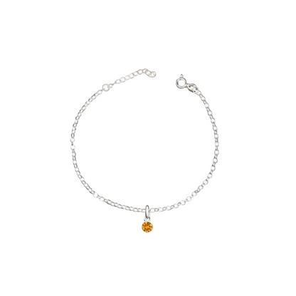 Silver bracelet with a small orange gemstone on a white background