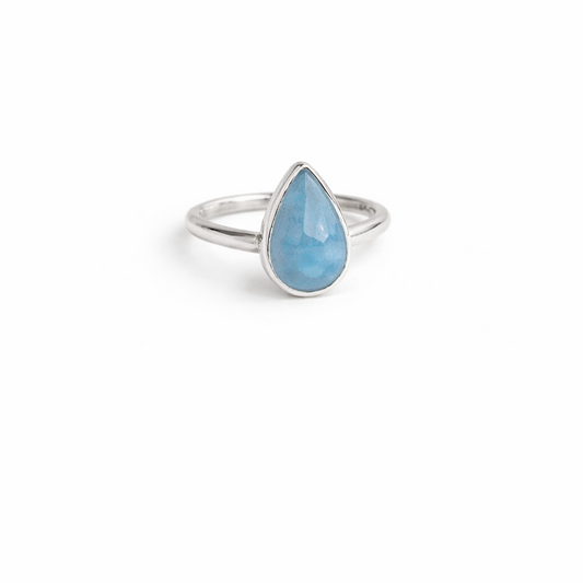 Ring with a blue teardrop-shaped stone on a white background