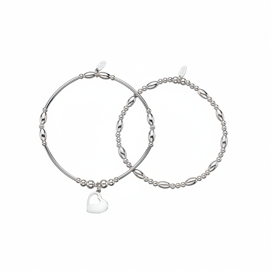 a pair of silver beaded bracelets, one with a heart, one without.