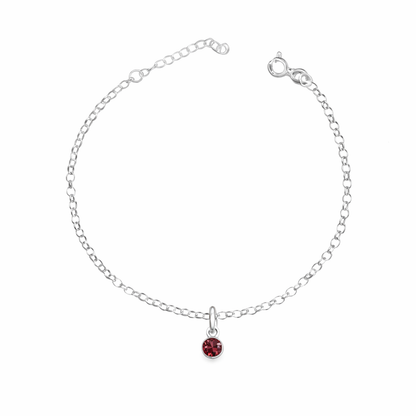 Silver bracelet with a red gemstone on a white background