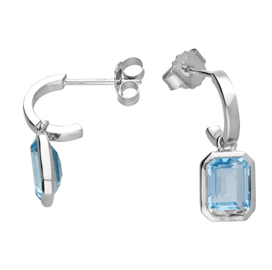 Silver hoop earrings with blue topaz gemstones on a white background