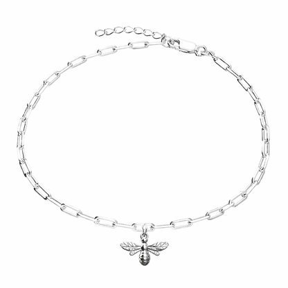 Silver trace bracelet with a bee charm on a white background
