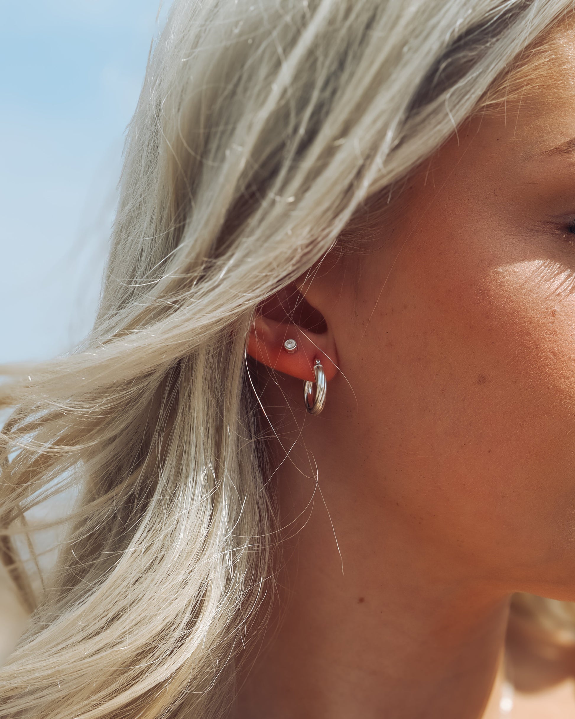 Close-up of a person wearing earrings with a blurred background