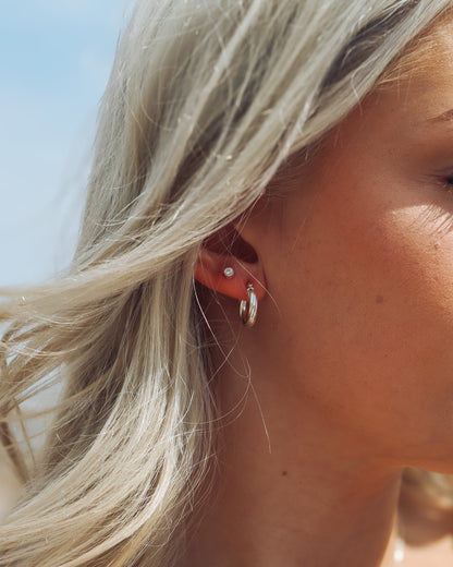Close-up of a person wearing earrings with a blurred background