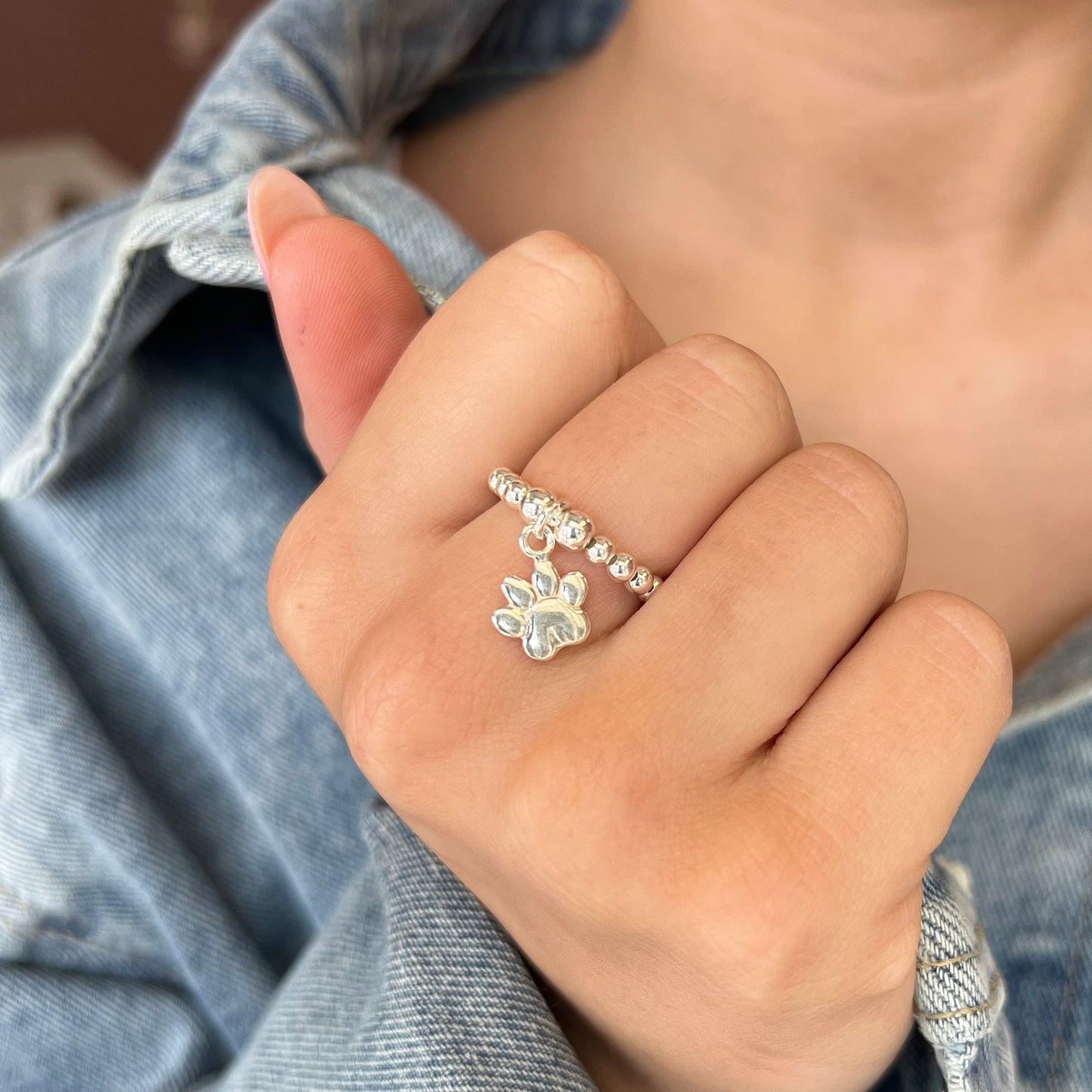 Hand wearing a diamond ring with a denim jacket
