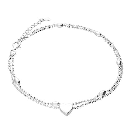 Silver anklet with a heart-shaped charm on a white background