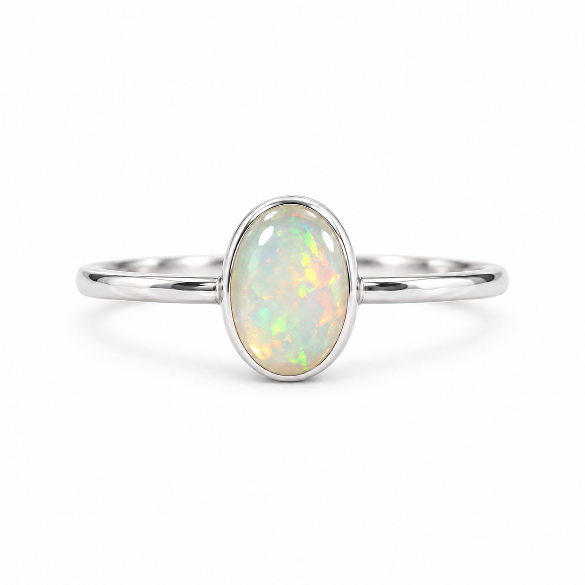A silver ring featuring a round bezel-set iridescent opal gemstone, shown against a plain white background.