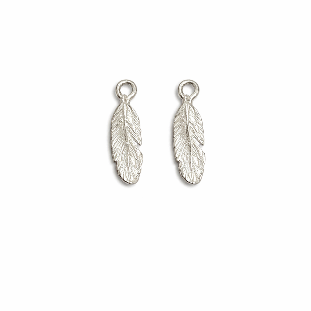 Two silver feather-shaped charms on a white background