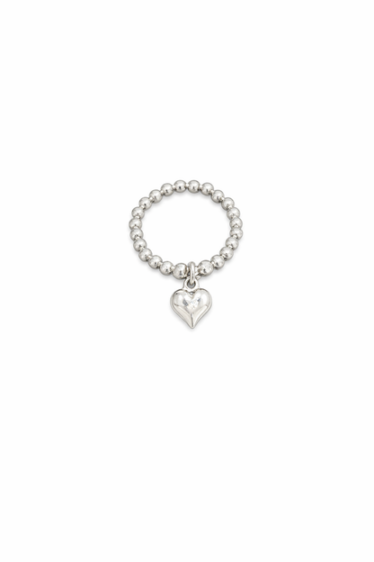 Silver beaded ring with a heart charm on a white background