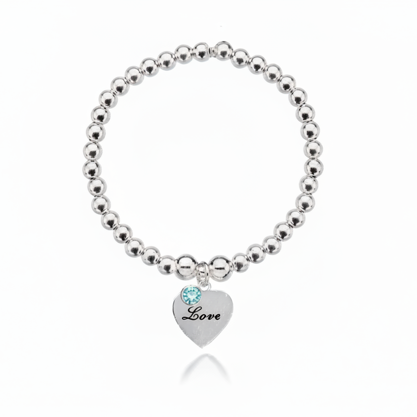 Silver beaded bracelet with a heart-shaped tag and blue gemstone on a white background