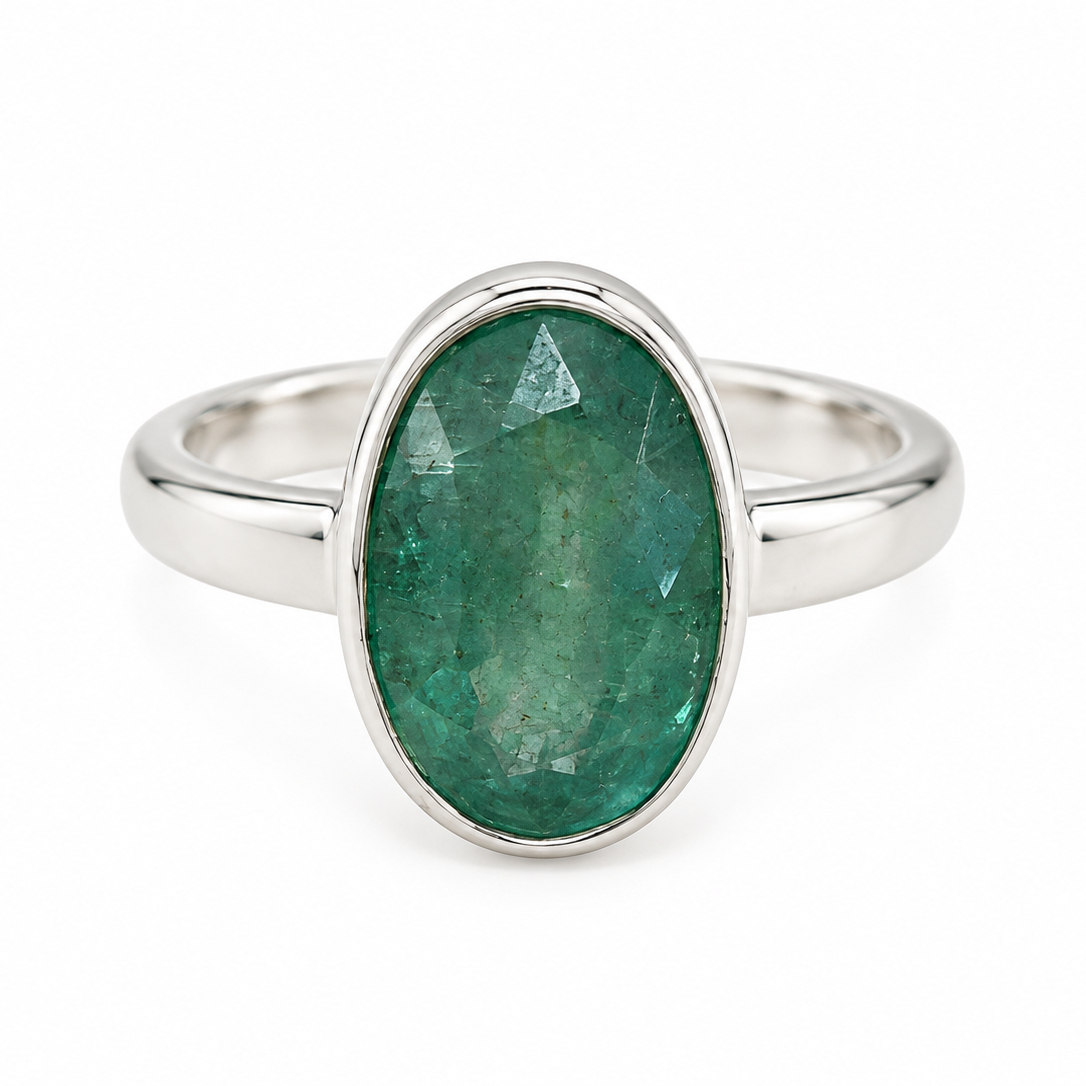 An oval-cut green kyanite  gemstone ring set in a polished silver band, shown against a plain white background.