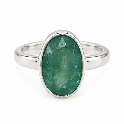 An oval-cut green kyanite  gemstone ring set in a polished silver band, shown against a plain white background.