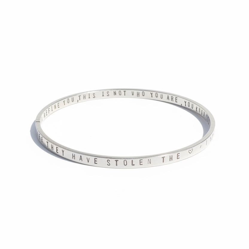 Silver bracelet with engraved text on a white background