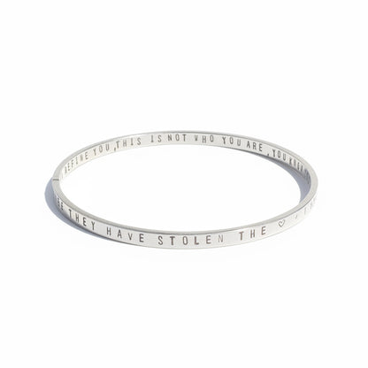 Silver bracelet with engraved text on a white background
