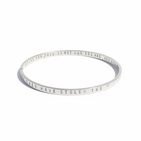 Silver bracelet with engraved text on a white background