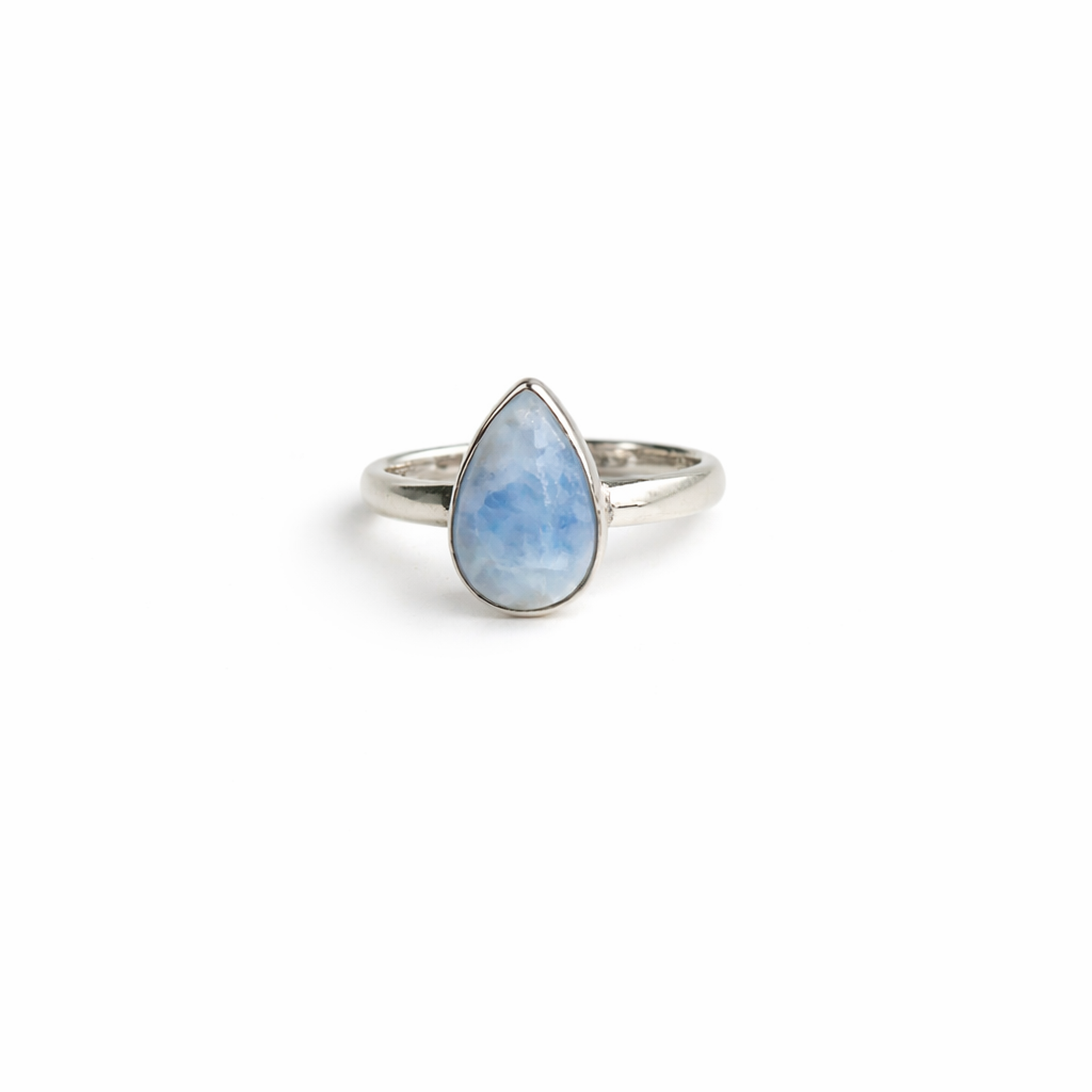 Silver ring with a teardrop-shaped blue stone on a white background