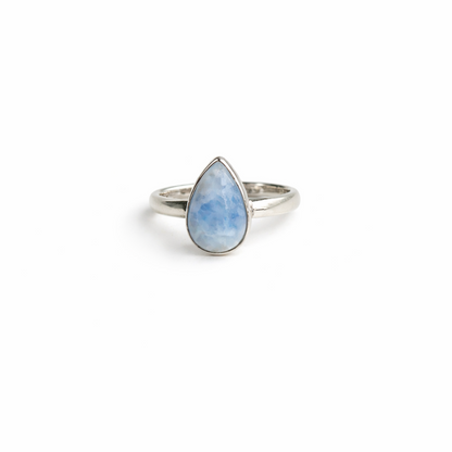Silver ring with a teardrop-shaped blue stone on a white background