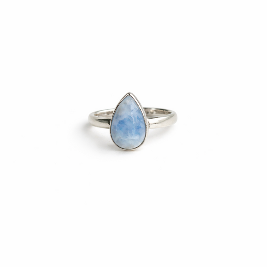 Silver ring with a teardrop-shaped blue stone on a white background