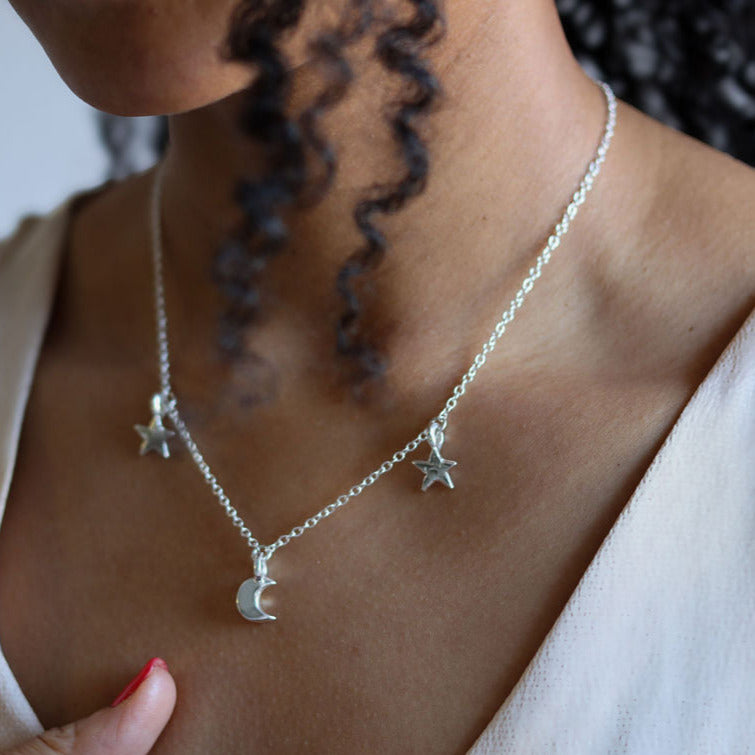 Triple charm star and moon necklace displayed on Leanne 