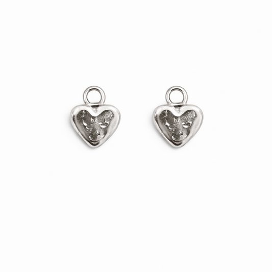 Two silver heart-shaped charms on a white background