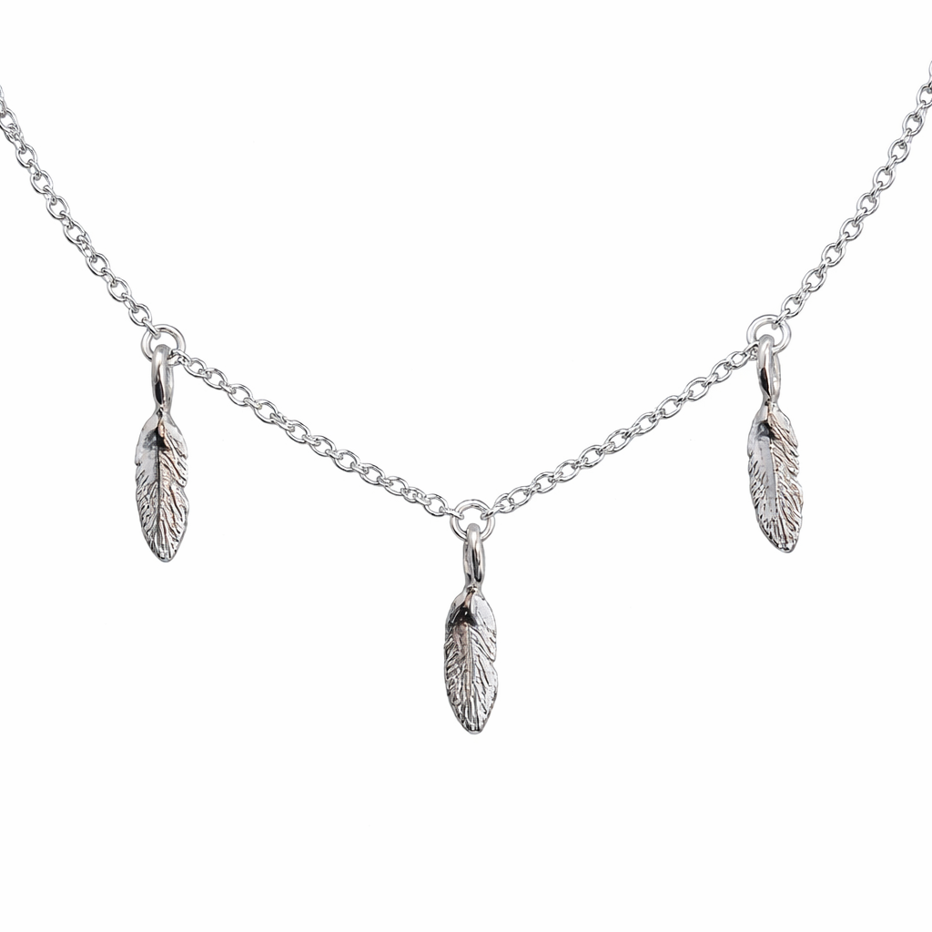 Silver necklace with feather pendants on a white background
