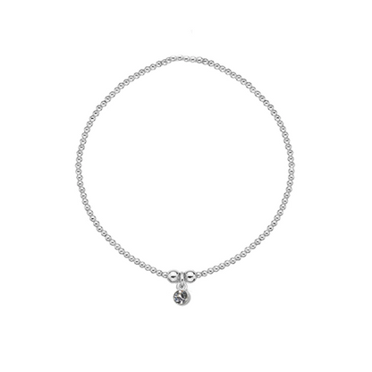 Silver bracelet with a small charm on a white background
