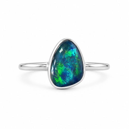 A silver band ring featuring a teardrop-shaped australian opal gemstone with vibrant blue and green iridescent play-of-color, set against a clean white background.