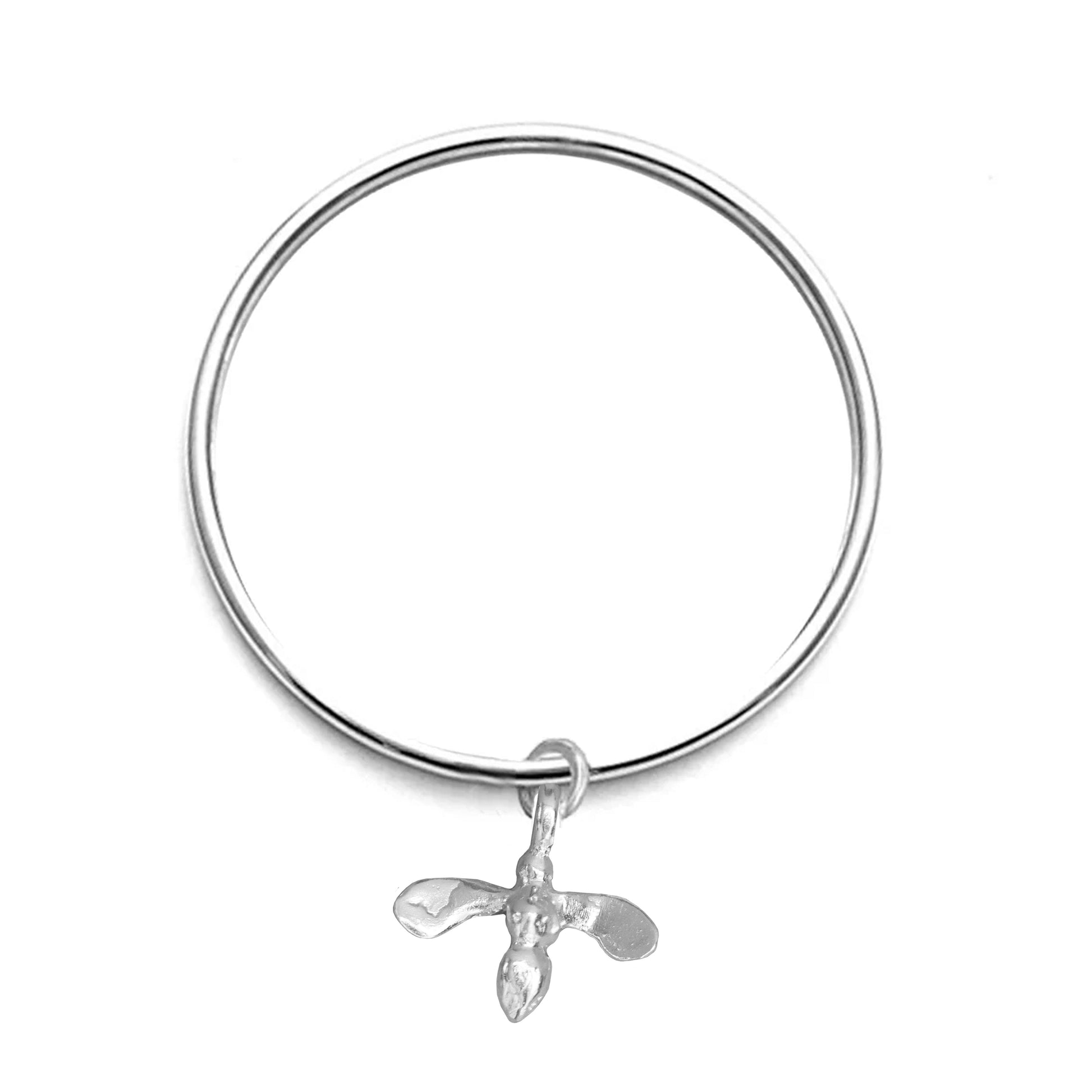 Silver bangle with a honey bee pendant on a white background