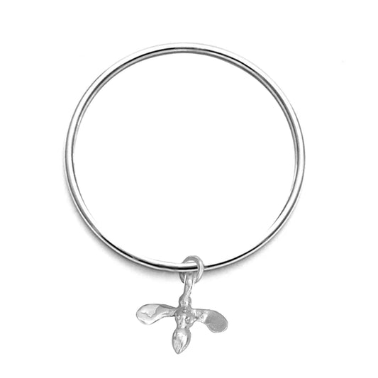 Silver bangle with a honey bee pendant on a white background