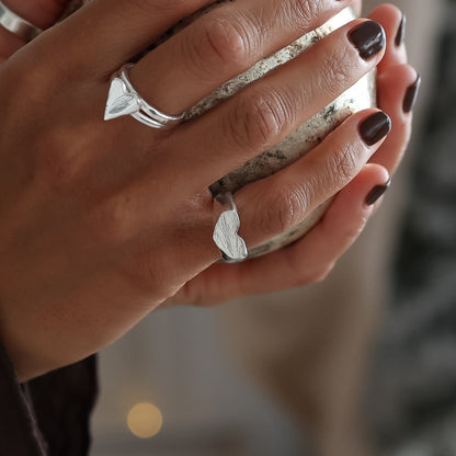 Hand holding a small ornament with blurred lights and decorative elements in the background
