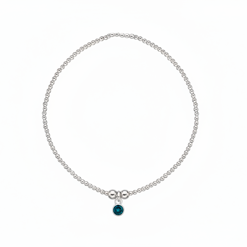 Silver bracelet with a blue gemstone on a white background