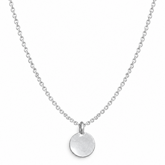 A silver chain necklace with a flat, circular disc pendant, photographed against a plain white background.