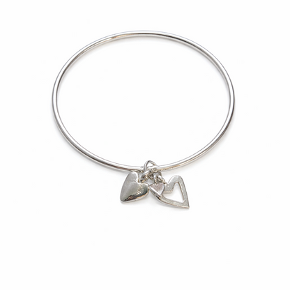 Sterling silver Endless Love Bangle with a solid heart charm and an open heart charm on a white background