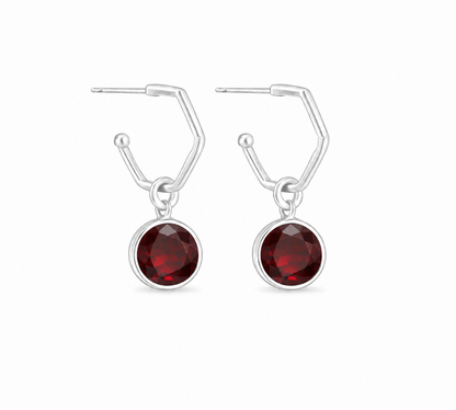 a  pair of sterling silver hoops with a garnet gemstone
