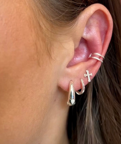 Close-up of an ear with multiple silver earrings