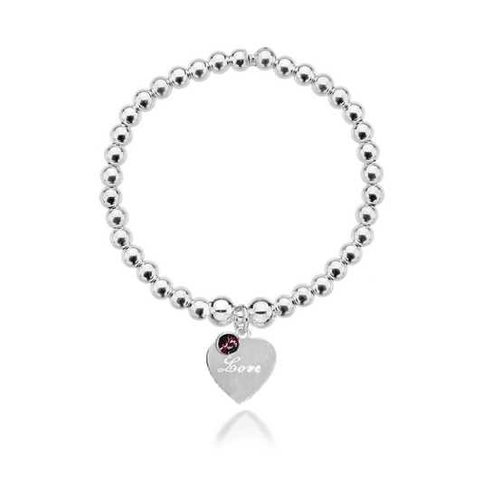 A silver bracelet with a heart-shaped charm engraved with the name 'Susan', featuring a birthstone for February (Amethyst), displayed on a person's wrist.