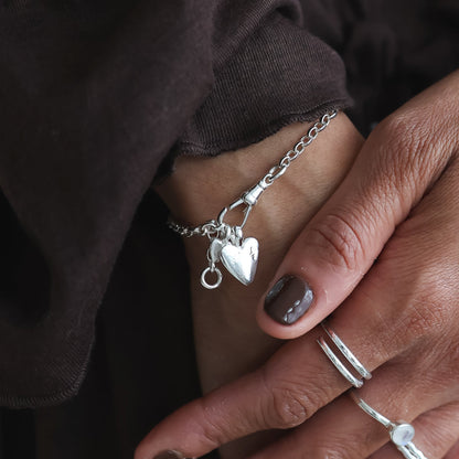 Close-up of hands with jewelry wearing a dark brown garment.