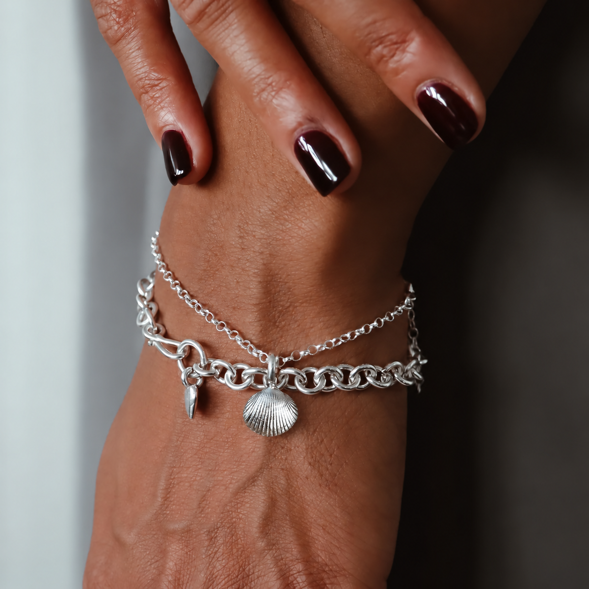 Sterling silver bracelet with a Cleethorpes cockle shell charm on a womans wrist