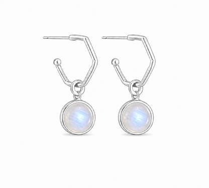 A pair of silver huggie hoop earrings with circular white moonstone dangle charms, shown on a clean white background.