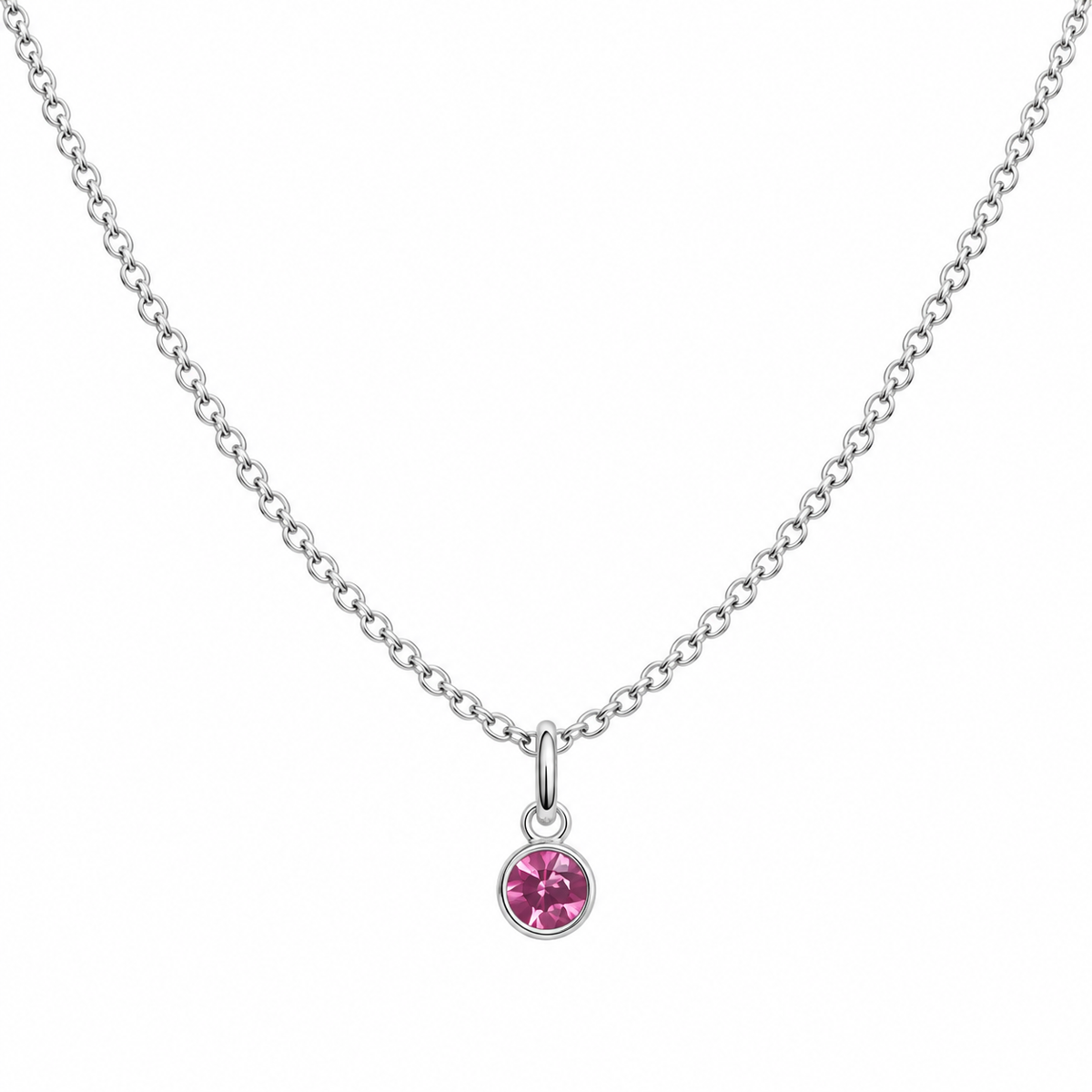 A delicate silver chain necklace with a small round bezel-set pink gemstone pendant, displayed against a solid white background.