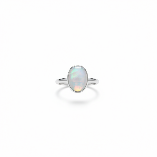 sterling silver Oval Moonstone Ring with an iridescent pale stone in a smooth bezel setting on a white background.