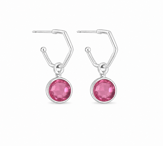 a pair of silver hoops featruing round pink tourmaline charms. On a white background
