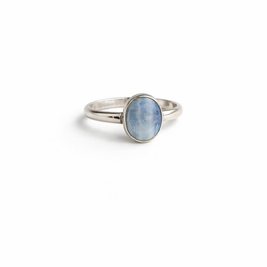 Silver ring with a blue stone on a white background