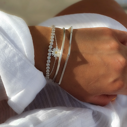 Sterling silver Polished Stacking Bangle worn with another silver bangle, a daisy bracelet and a stone-set bracelet