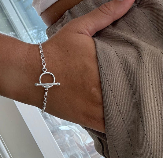 Silver t bar bracelet on leah with a neutral background