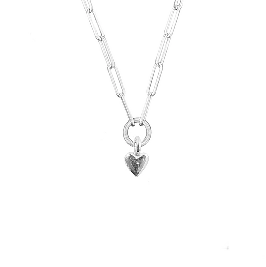 A silver necklace with a small heart-shaped pendant, displayed against a white background.