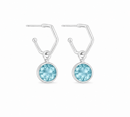 A pair of silver drop hoop earrings with round light blue gemstone pendants, shown against a plain white background.